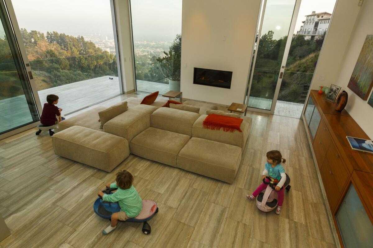 Today, new sleek travertine floors create an ideal racetrack for (l-r) Dean, 6, Reed, 3, and Sloane, 4.