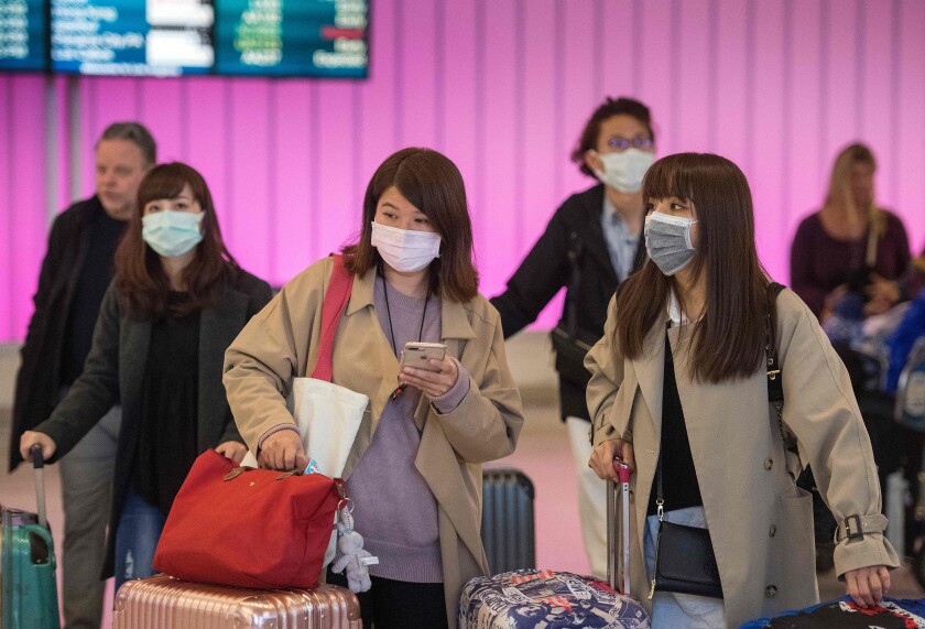 Passengers wear masks as they arrive at LAX.