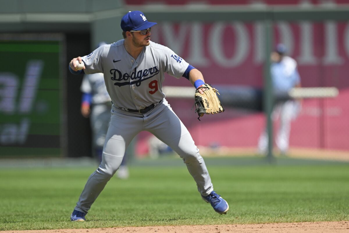 Dodgers second baseman Gavin Lux fields a grounder and throws to first base.