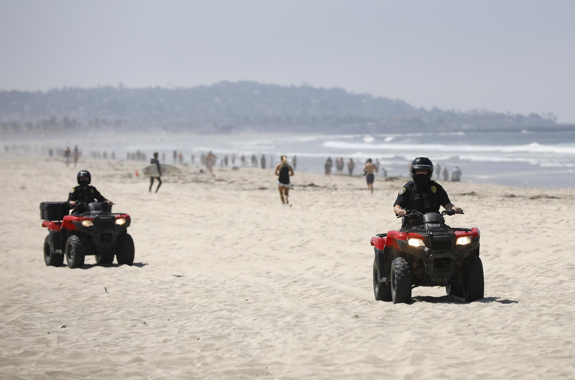 San Diego Police officers patrol Pacific Beach after local beaches reopened to activities such as walking, running, and surfing on April 27, 2020. Beaches have been closed for several weeks due to the coronavirus. The boardwalks and congregating on the sand are still prohibited.