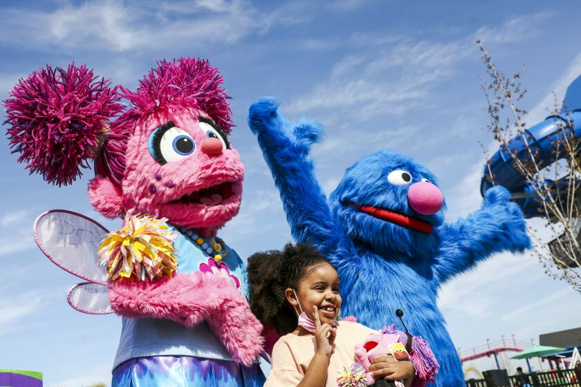 SAN DIEGO, CA - MARCH 25: Alana Bergins, 6, poses with Sesame Street characters during the exclusive media preview to Sesame Place San Diego on Friday, March 25, 2022 in San Diego, CA. The park will officially open to the public on March 26th. (Dania Maxwell / Los Angeles Times)