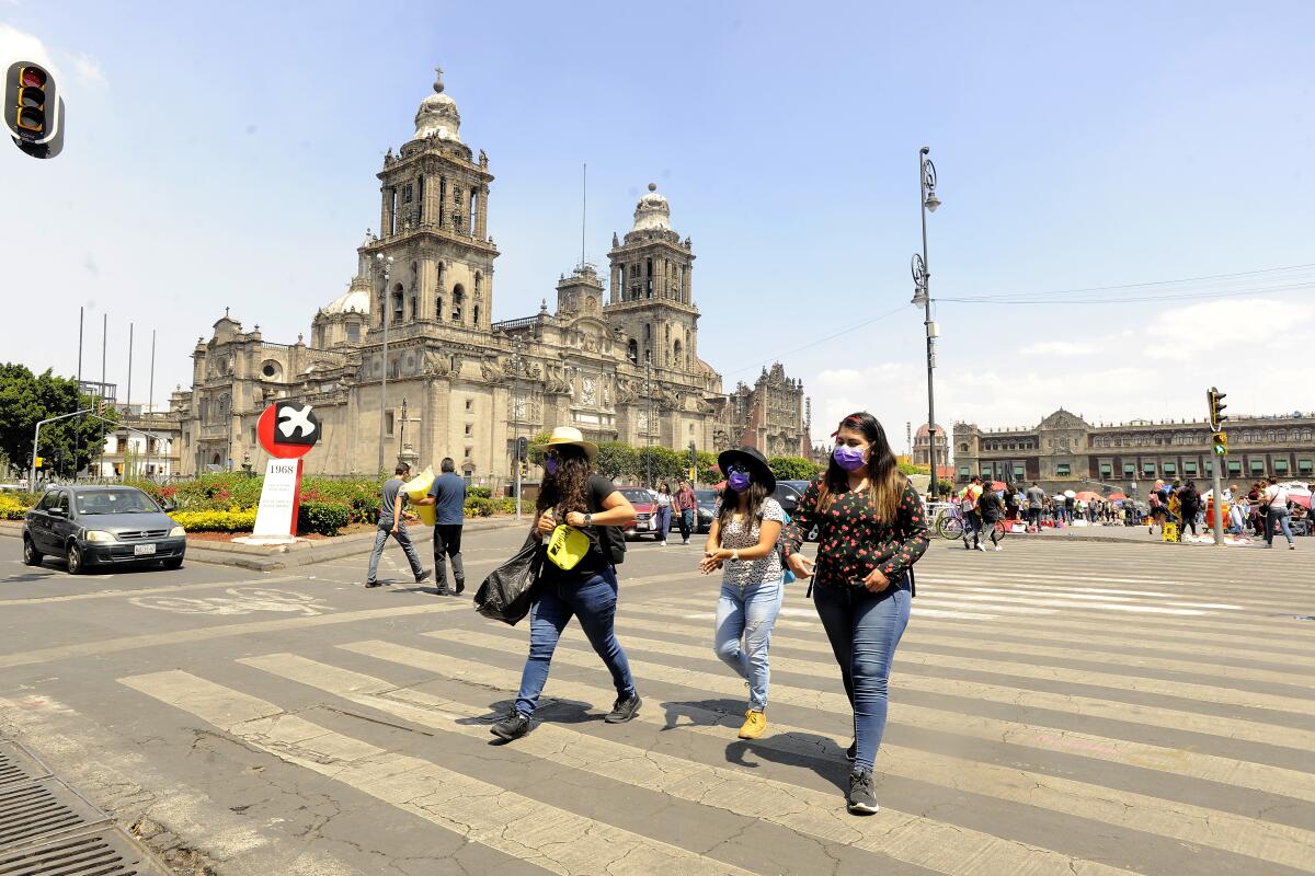 Pedestrians walk wearing masks as a preventive measure against the spread of Coronavirus in Mexico City, Mexico. The government has called the society to keep the measures such as cleaning hands and wearing masks.