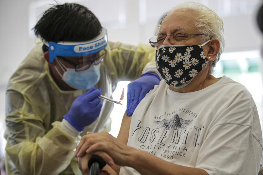 Lakewood, CA - March 31: Bryan Phan, a RN, left, administers a Johnson & Johnson COVID-19 vaccine to Ana Klee, 71, at a coronavirus vaccination clinic established by L.A. County Department of Public Health at Whispering Fountains Senior Living Community on Wednesday, March 31, 2021 in Lakewood, CA.(Irfan Khan / Los Angeles Times)