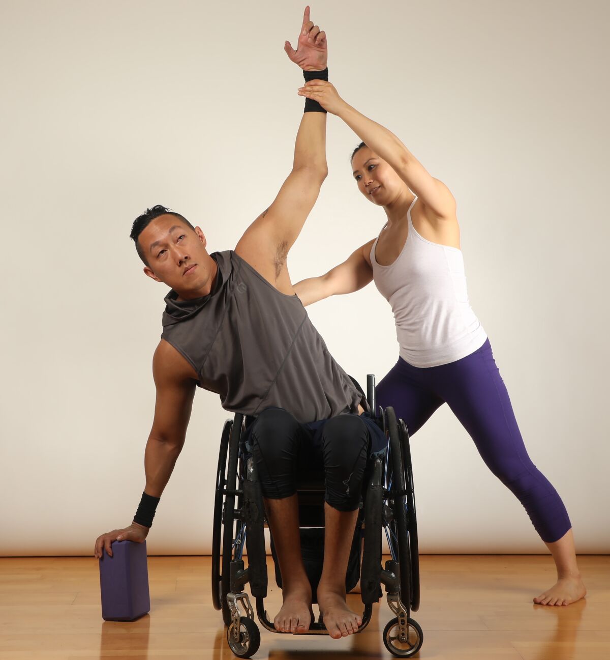 Dr. Ingrid Yang and James Sa demonstrate the Seated Extended Triangle pose, used in adaptive wheelchair yoga.