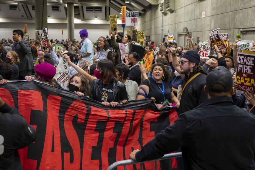 Pro-Palestinian demonstrators enter the convention hall during the afternoon session of the 2023 California Democratic Party November State Endorsing Convention, Saturday, Nov. 18, 2023, at SAFE Credit Union Convention Center in Sacramento. Calif. (Lezlie Sterling/The Sacramento Bee via AP)