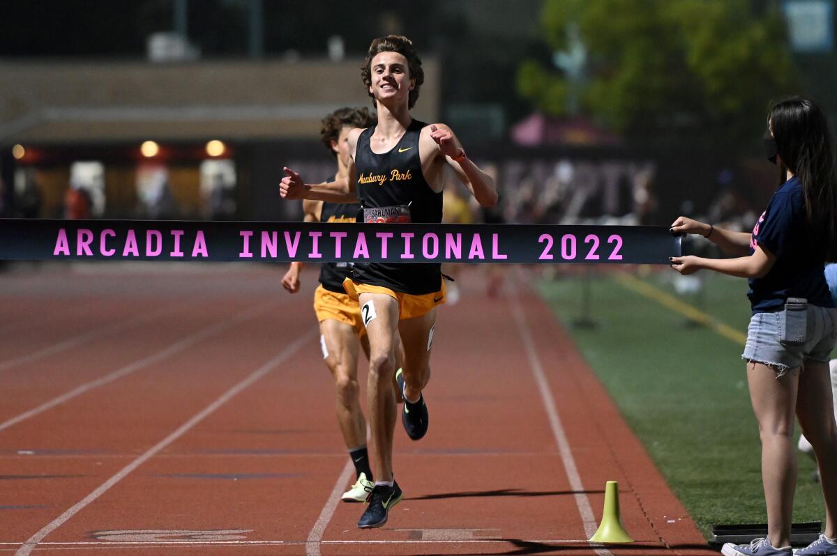 Newbury Park's Colin Sahlman crosses the finish line, winning a boys' 3,200-meter race