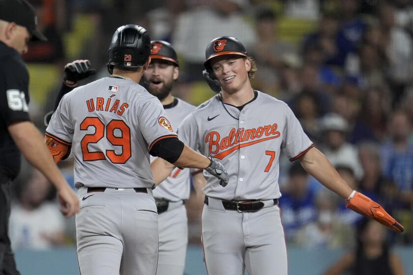 El mexicano Ramón Urías, de los Orioles de Baltimore, festeja con su compañero Jackson Holliday, luego de batear un jonrón en el encuentro ante los Dodgers de Los Ángeles, el martes 27 de agosto de 2024 AP Foto/Marcio José Sánchez)