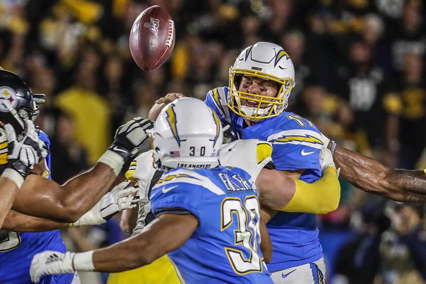 Chargers quarterback Philip Rivers is hit by Steelers linebacker T.J. Watt as he tries to pass the ball to Austin Ekeler during Sunday's 24-17 loss.