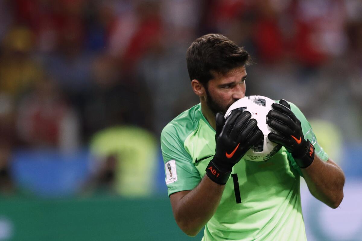 FILE - In this Wednesday, June 27, 2018 file photo, Brazil goalkeeper Alisson kisses the ball after makes a save during their World Cup soccer match against Serbia. There will be no more kissing the ball for good luck in South American soccer. Forget about exchanging jerseys and even spitting or blowing noses on the field also. The soccer governing body of soccer in the region has released a series of specific regulations amid the coronavirus pandemic to protect everyone’s health when the Copa Libertadores eventually resumes. There is no date set for when the tournament will restart. (AP Photo/Matthias Schrader)