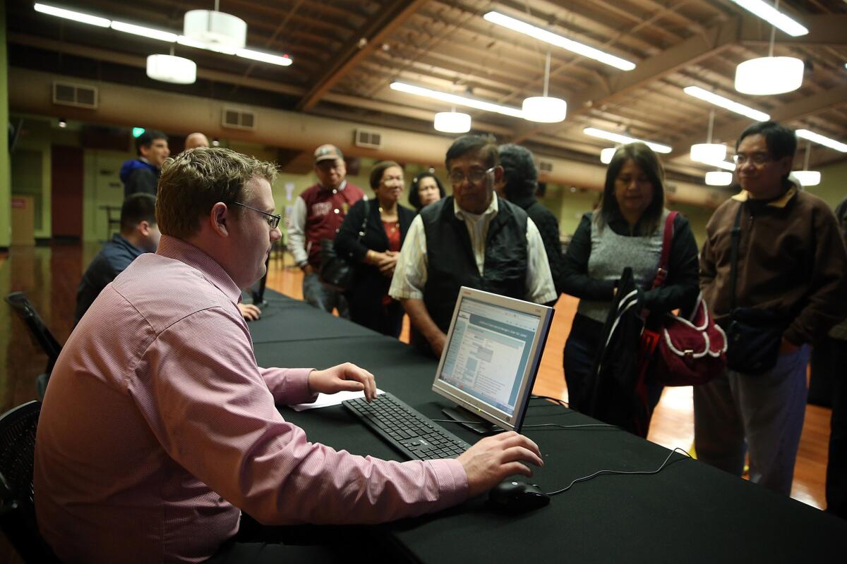 A worker registers job seekers during a job fair at California's Great America theme park on in Santa Clara in February.