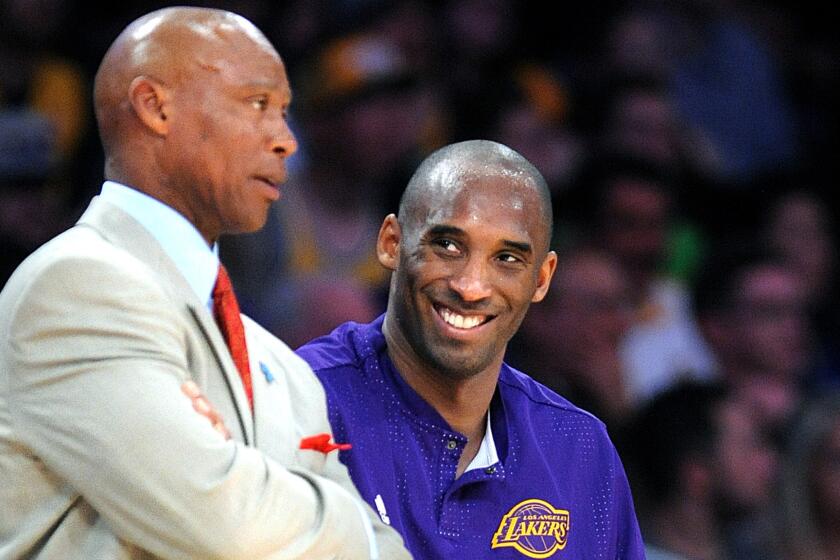 Lakers Coach Byron Scott chats with guard Kobe Bryant during a game against the Celtics on Sunday.