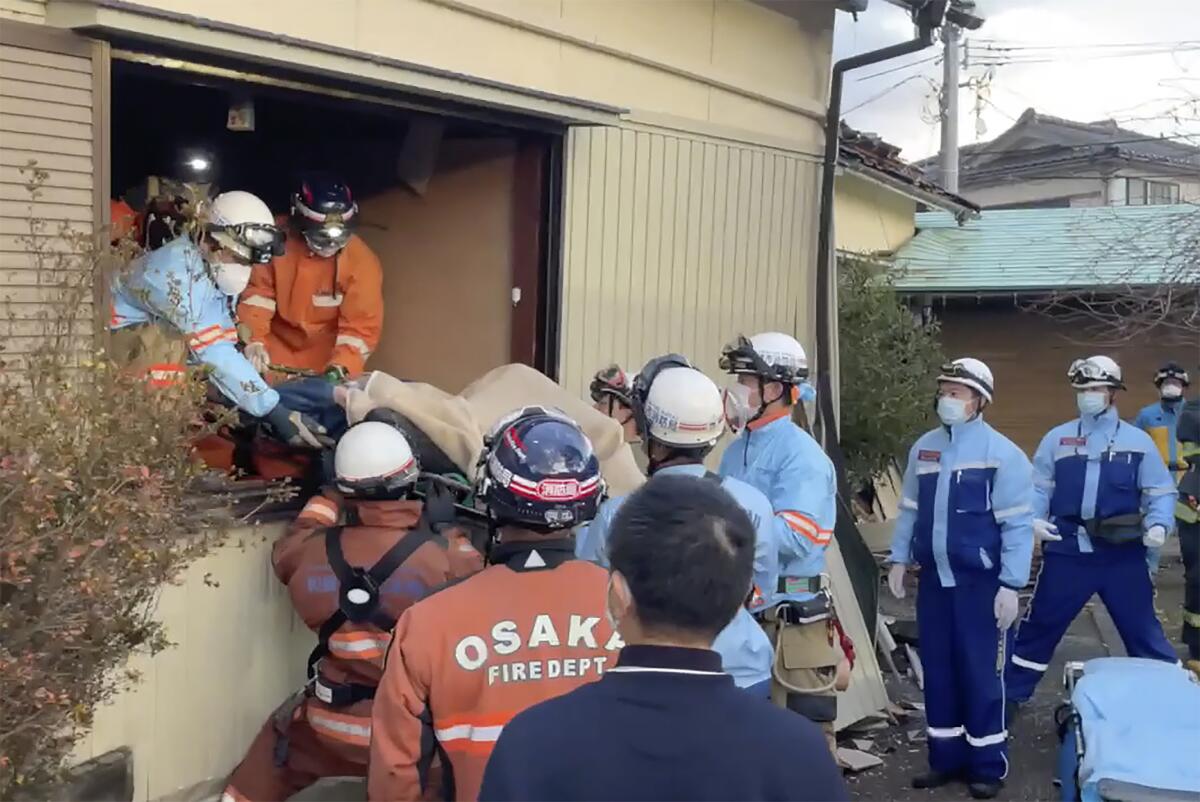 Woman on a stretcher being removed from quake-destroyed house