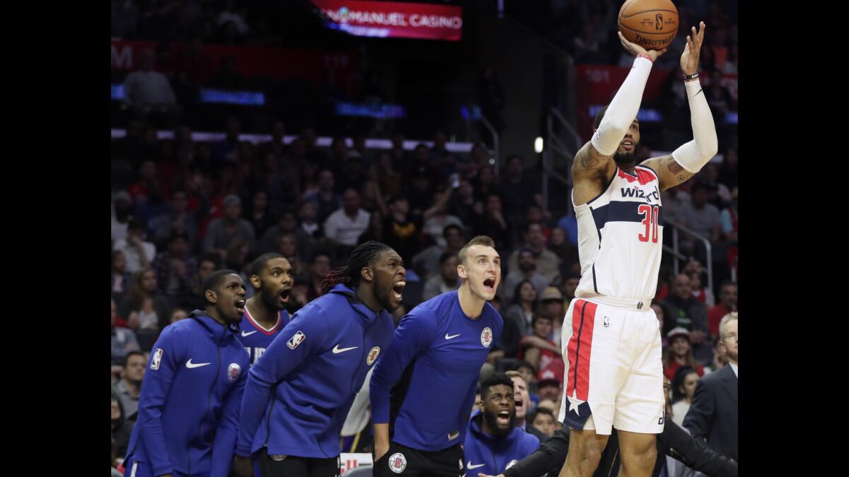Clippers players scream in an effort to distract forward Mike Scott as he shoots a three pointer in the second half at Staples Center.