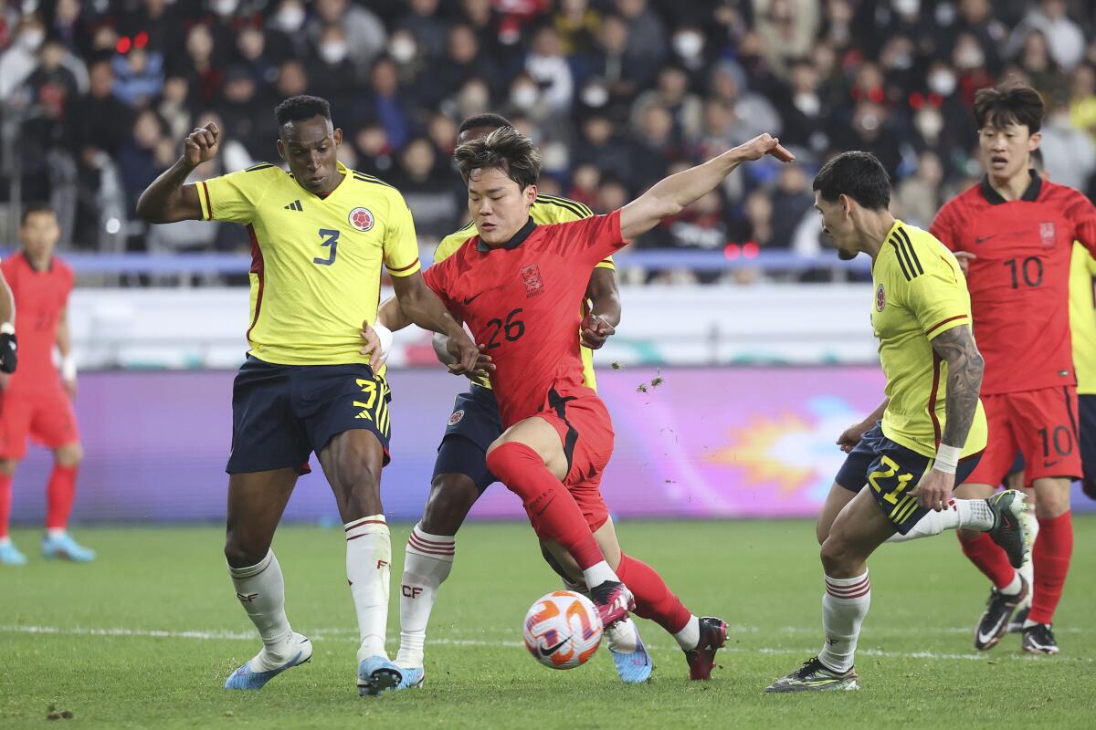 Oh Hyeon-gyu de Corea del Sur pelea para avanzar con el balón mientras lo defiende Jhon Lucumi 