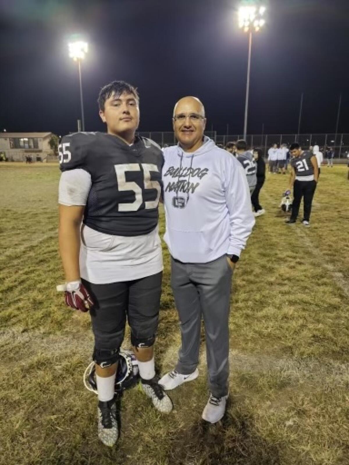 Garfield football coach Lorenzo Hernandez poses for a photo with his son, Noah, who starts at offensive guard.