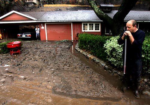Southern California's long dry spell ended Friday, with an unexpectedly strong rainstorm leading to evacuations in the Orange County canyon communities scarred by Octobers brush fires. Marcus Lynch, above, takes a break from shoveling mud in front of the house of Gene Corona of Modjeska Canyon, one of the areas susceptible to debris flows because of the rain.
