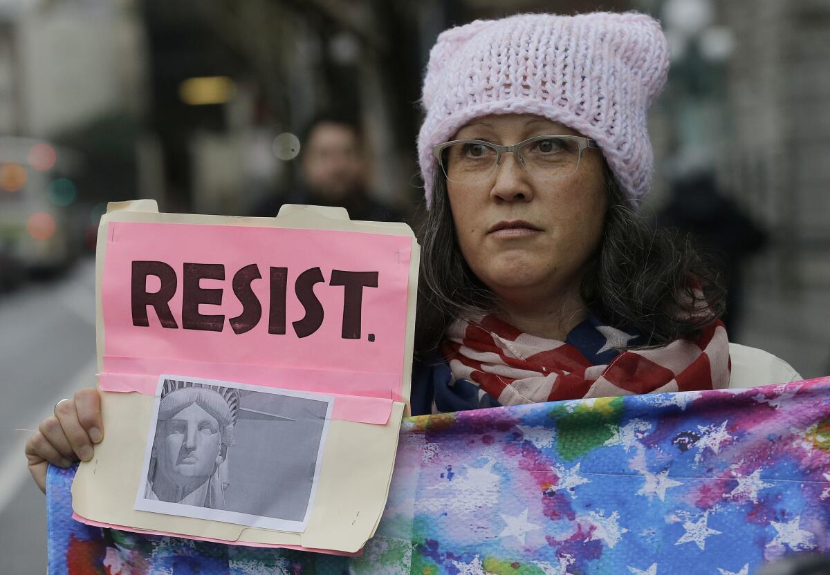 Dina Cehand holds a sign outside of the U.S. 9th Circuit Court of Appeals in San Francisco.