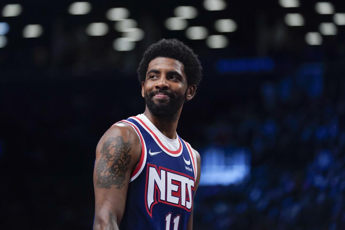 Brooklyn Nets guard Kyrie Irving smiles during a game.