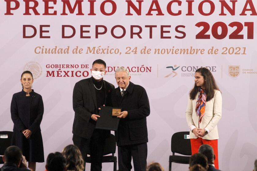 MEXICO CITY, MEXICO - NOVEMBER 24, 2021: Mexico's President Andrés Manuel López Obrador, accompanied by director of the National Sports Commission (Conade) Ana Gabriela Guevara and Mexico Citys Mayor Claudia Sheinbaum delivery the Award to to baseball player Julio César Urías Acosta in the professional sports category, during the ceremony for the delivery of the National Sports Awards at National Palace. On November 24, 2021 In Mexico City, Mexico. (Photo credit should read Luis Barron / Eyepix Group/Barcroft Media via Getty Images)