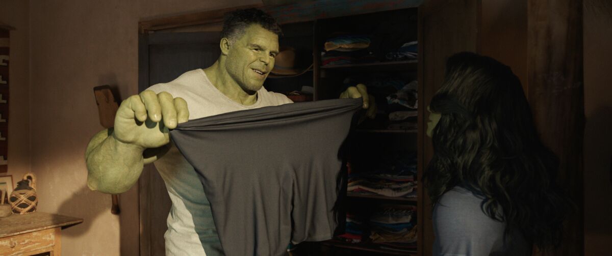 a giant green man holding up a pair of spandex shorts