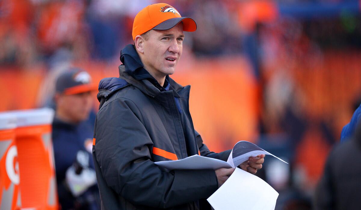 Denver Broncos injured quarterback Peyton Manning looks over game notes on the sideline during a game against the Oakland Raiders on Sunday.