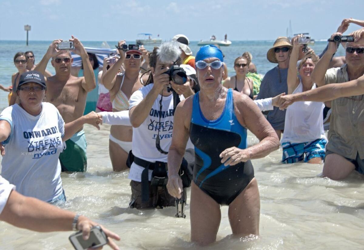 Diana Nyad emerges from the Atlantic Ocean after completing the swim from Cuba to Florida.
