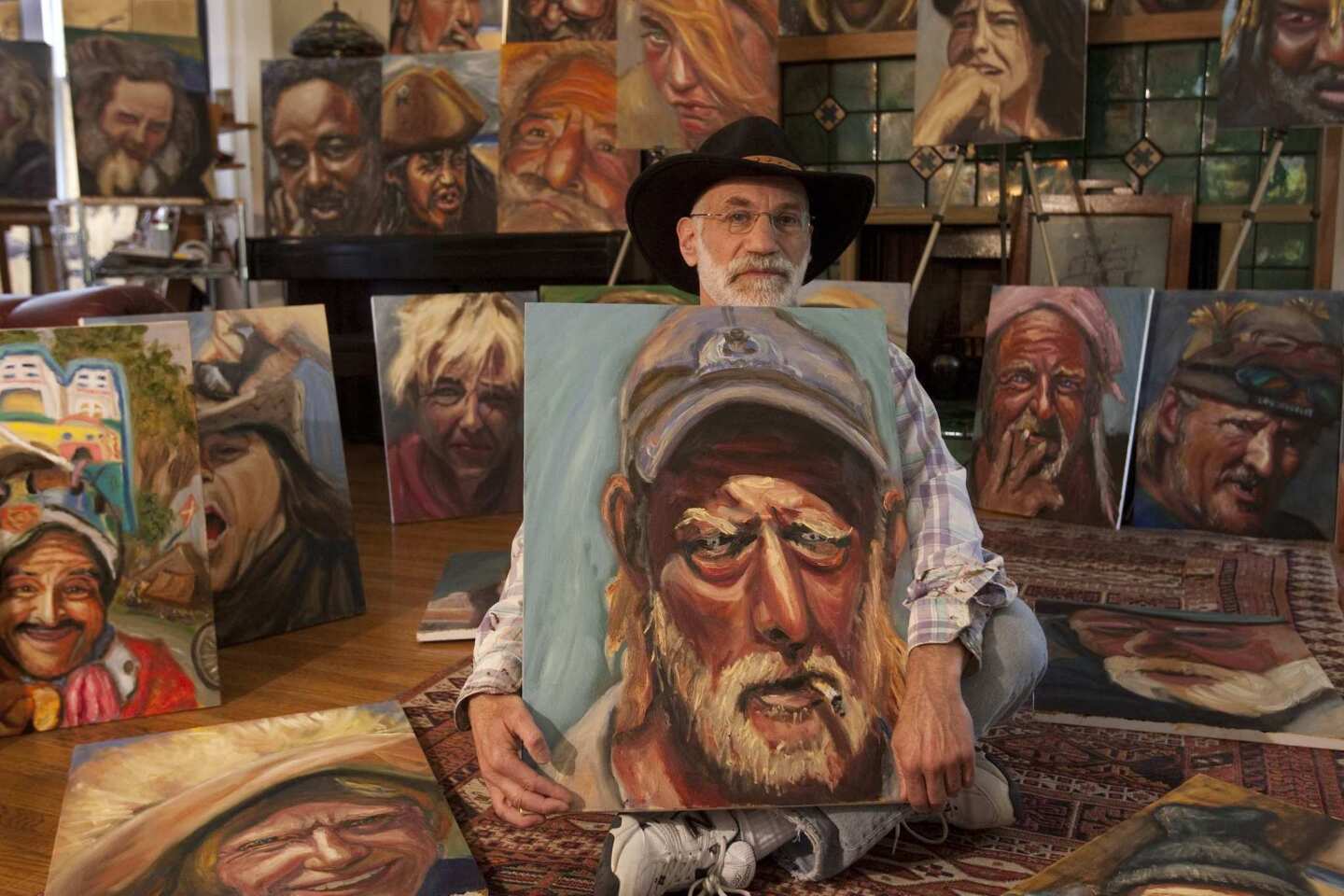 Stuart Perlman, shown surrounded by his portraits of homeless people he meets on the Venice Beach boardwalk, is a Santa Monica psychologist who has studied trauma survivors. For the last two years he has interviewed and painted the portraits of homeless people in Venice Beach. Here Perlman holds a portrait of Daniel, a former project leader at an architectural firm whose life spun out of control a dozen years ago after a drunk driver ran a red light and crashed into the family vehicle, killing his wife and children. Daniel was not in the vehicle.