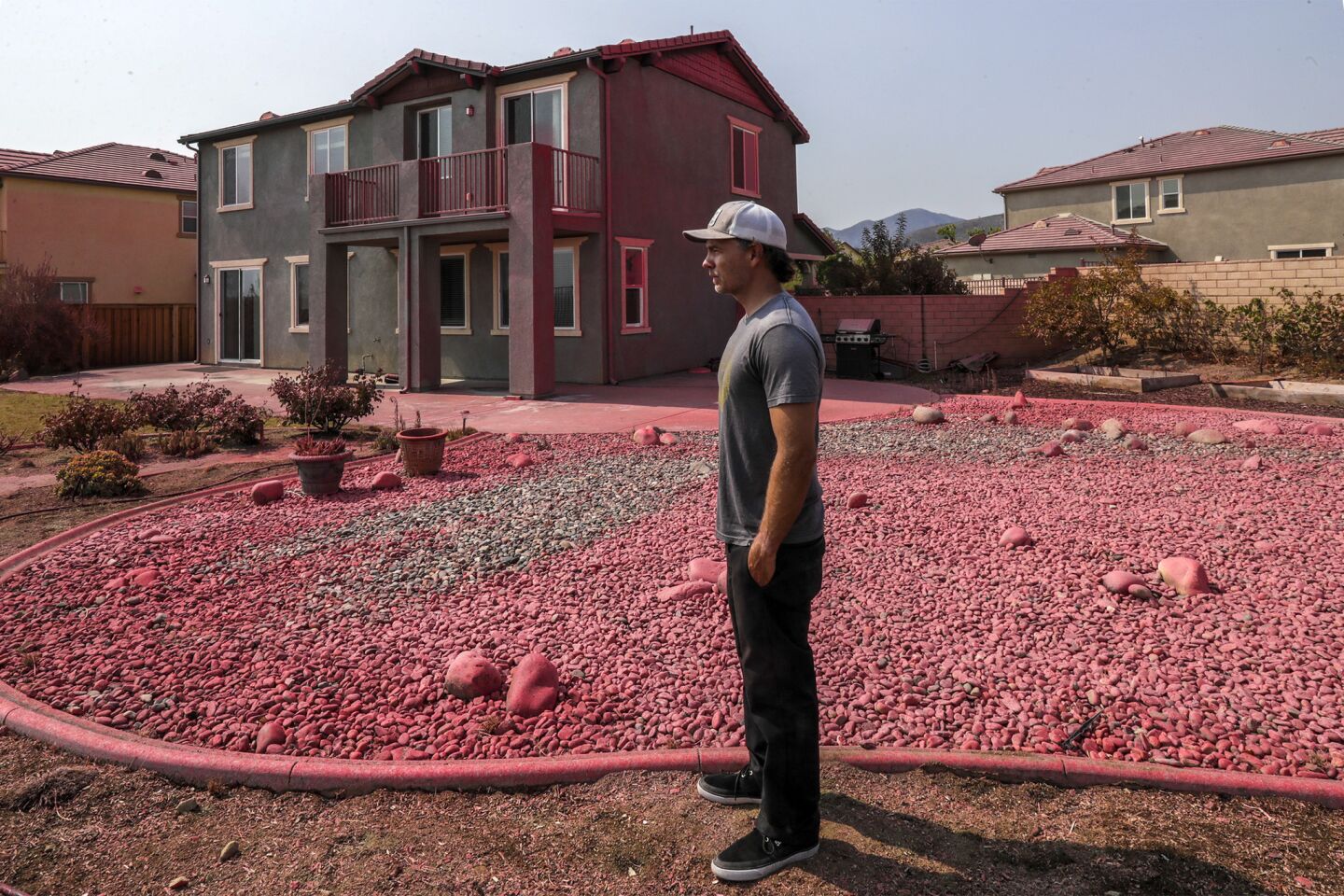 Kenneth Leishman's home is pink from fire retardant in the McVicker Canyon neighborhood of Lake Elsinore. Leishman stayed to protect his house from the fire.