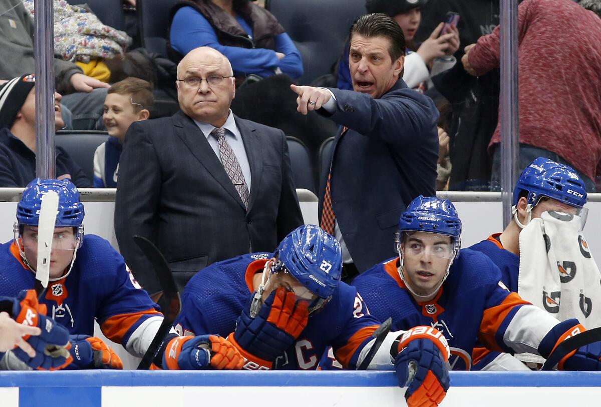 FILE - New York Islanders head coach Barry Trotz, left, and assistant coach Lane Lambert stand on the bench during an NHL hockey game against the Philadelphia Flyers on Monday, Jan. 17, 2022, in Elmont, N.Y. The New York Islanders have hired longtime Barry Trotz assistant and right-hand man Lane Lambert to succeed him as coach. General manager Lou Lamoriello announced Lambert as Trotz's replacement Monday, May 16, a week after firing the Stanley Cup-winning coach who had one year remaining on his contract. (AP Photo/Jim McIsaac, File)