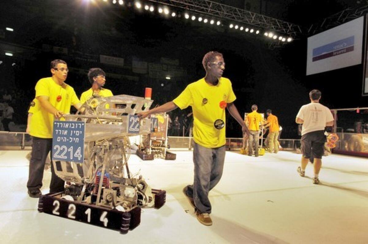 Yemin Orde Youth Village students with their robot, RobOrde, after a match to decide who will represent Israel at the FIRST Robotics Competition in Atlanta. Each robot is built from a standard set of hardware, with no instructions.