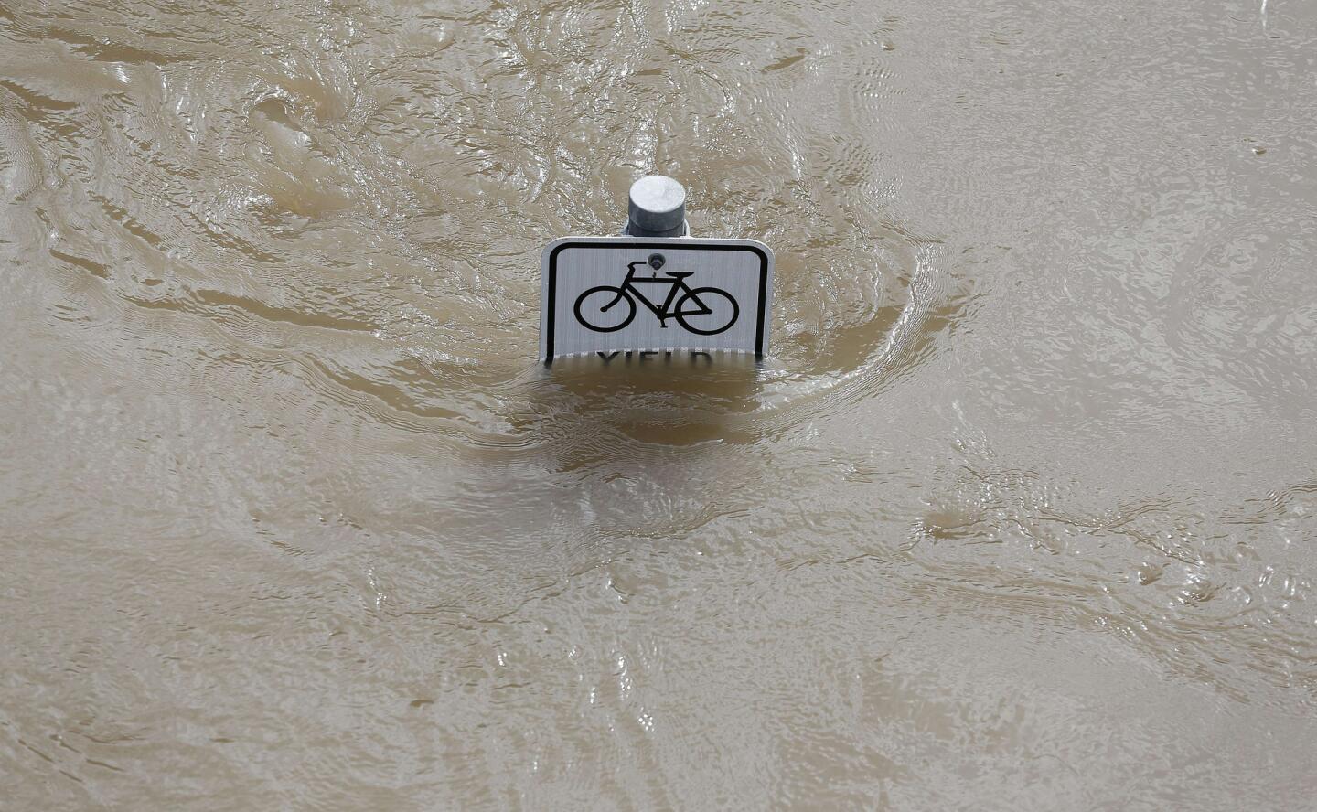 Water is seen at the top of a sign along a bike path near Memorial Drive in Houston, Texas on May 26, 2015.