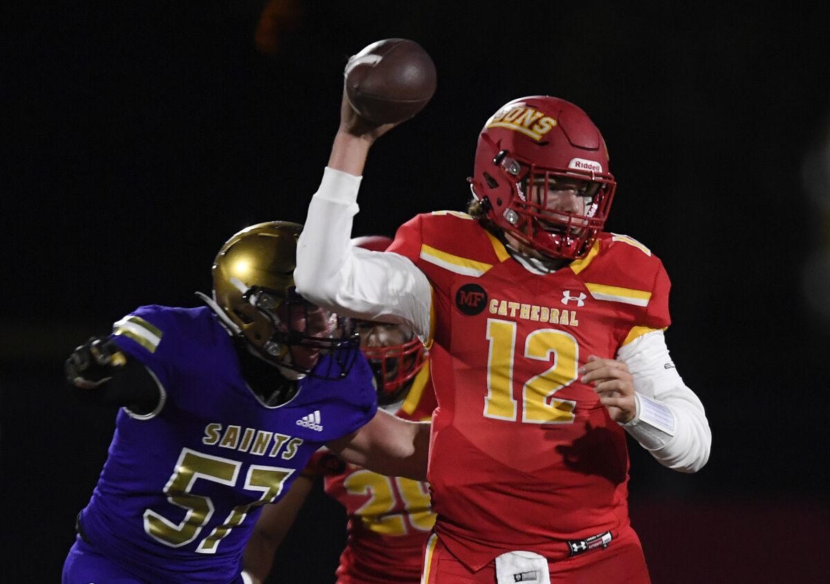 Cathedral Catholic's quarterback Charlie Mirer (12) looks to pass under pressure from St. Augustine's Christian Gaeta (57).