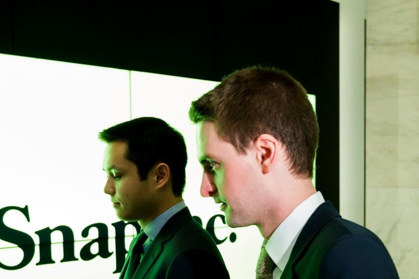 Snapchat co-founders Bobby Murphy, left, and Evan Spiegel stand together before shares of Snap Inc., the parent company of Snapchat, begin trading at the New York Stock Exchange.
