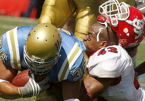 UCLA running back Kahlil Bell and Fresno State linebacker Chris Carter collide in the first half Saturday.