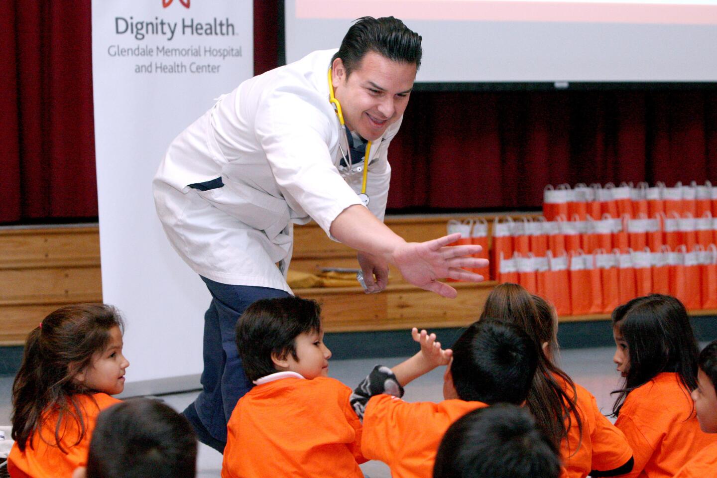 Dignity Health Glendale Memorial Hospital physician Dr. Antonio Zamorano gives a high five to a first grader to who answered a question correctly during his annual Teddy Clinic at Cerritos Elementary School in Glendale on Tuesday, Jan. 24, 2017. Dr. Zamorano talked about kindness and age-appropriate preventive health care tips.