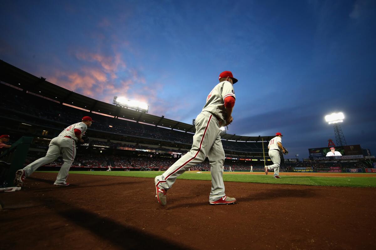 Phillies players run onto the field at Angel Stadium during a game in August 2017.