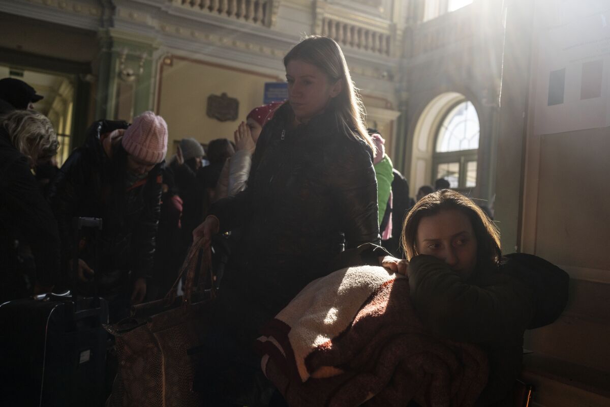 People who fled the war in Ukraine wait at the train station in Przemysl, southeastern Poland, Thursday, March 17, 2022. Russia's invasion of Ukraine entered its fourth week on Thursday, with Russian forces largely bogged down outside major cities and shelling them from a distance, raining havoc on civilians. (AP Photo/Petros Giannakouris)