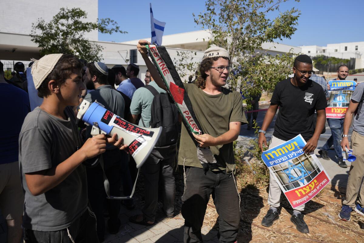 Right-wing Israelis, one holding a Palestinian scarf, at a protest outside military court hearing.