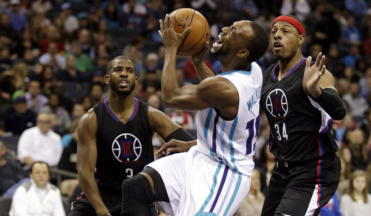 The Charlotte Hornets' Kemba Walker tries to get his shot off as he looks for a foul to be called against the Clippers' Chris Paul (3) or Paul Pierce during the first half on Wednesday.