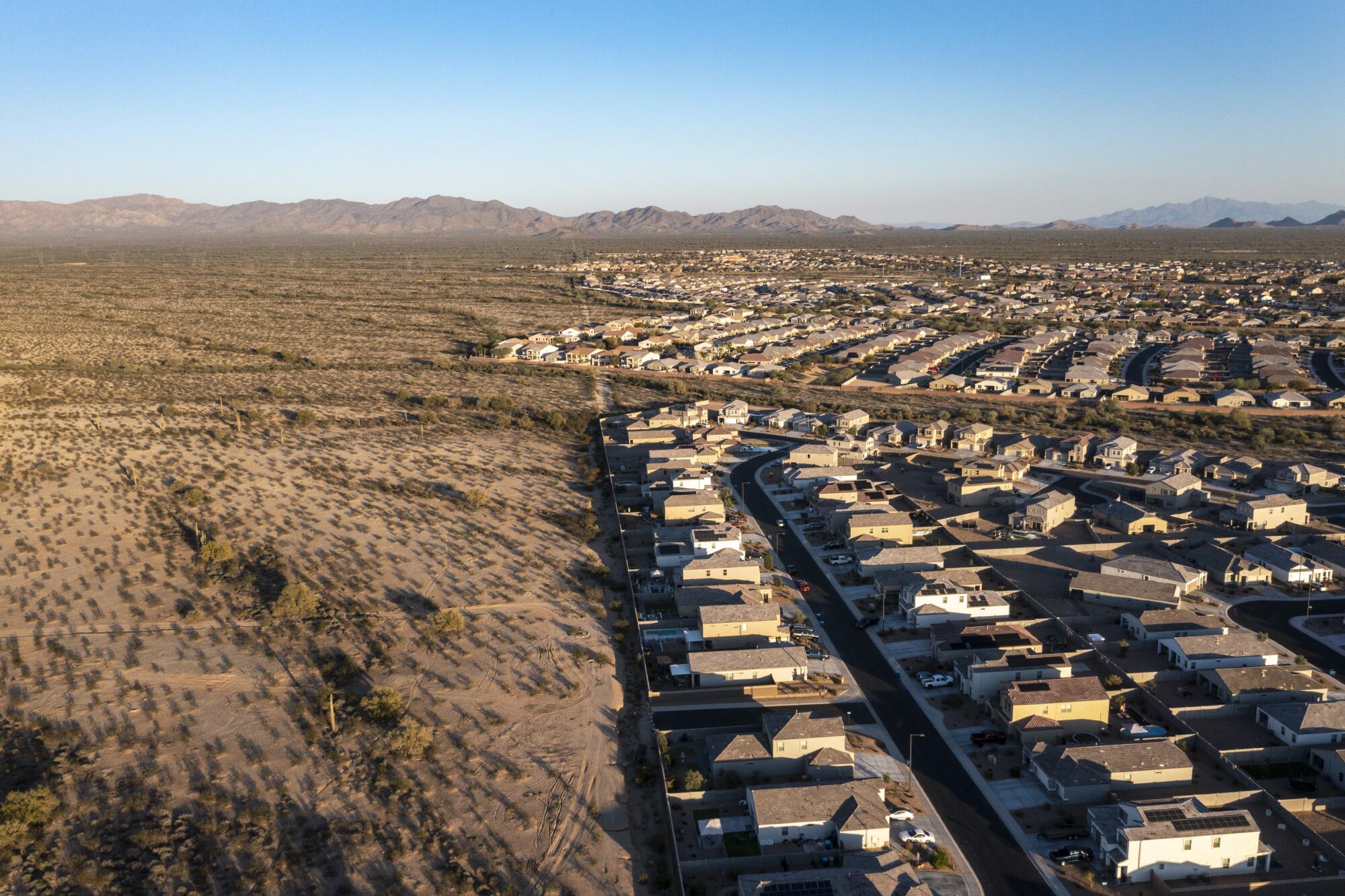 Homes, some with backyard swimming pools, where the suburbs meet the desert in Buckeye, Ariz.