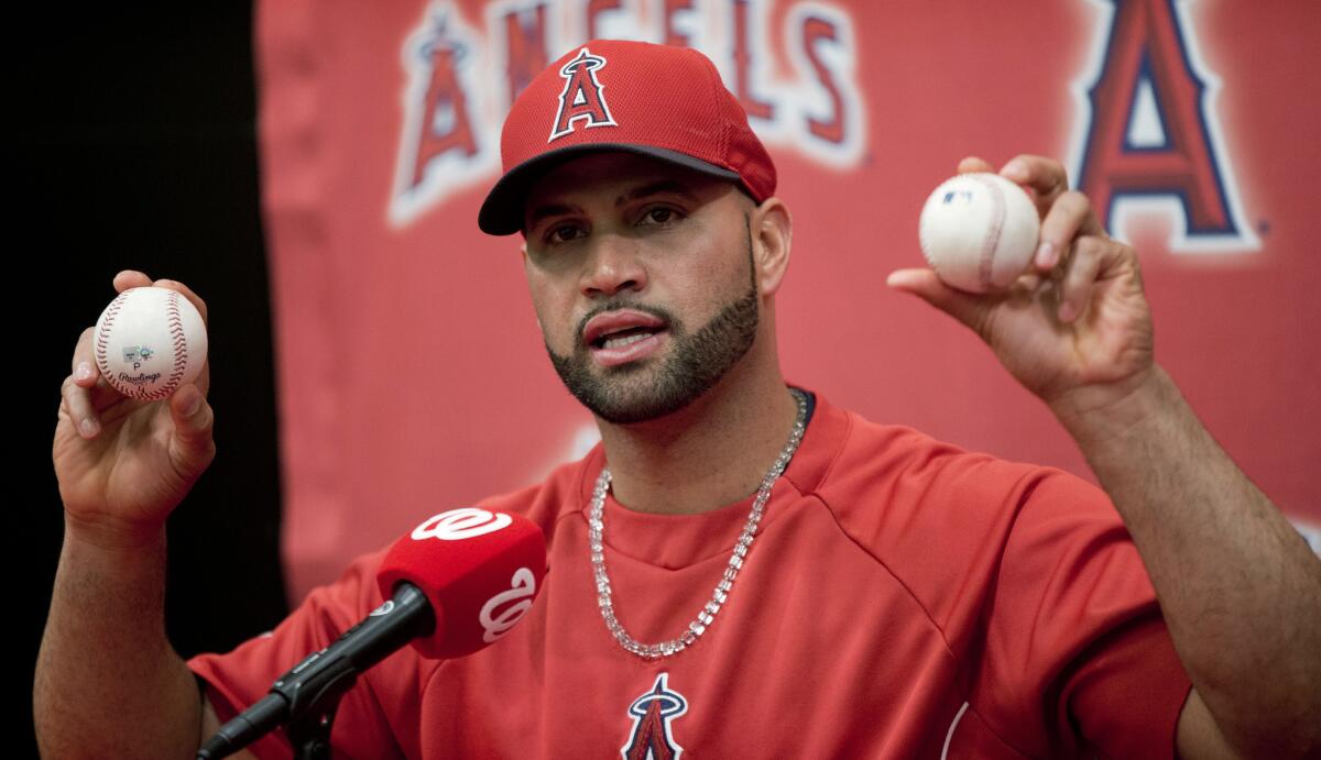 Angels slugger Albert Pujols holds up the balls he hit for his 499th, right, and 500th career home runs following the team's 7-2 win over the Washington Nationals on Tuesday.