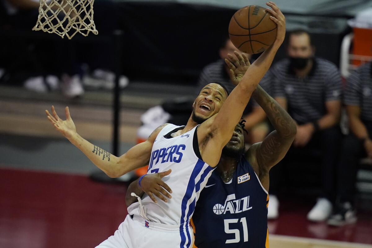 Clippers' Amir Coffey grabs a rebound over Utah Jazz's Jarell Martin.
