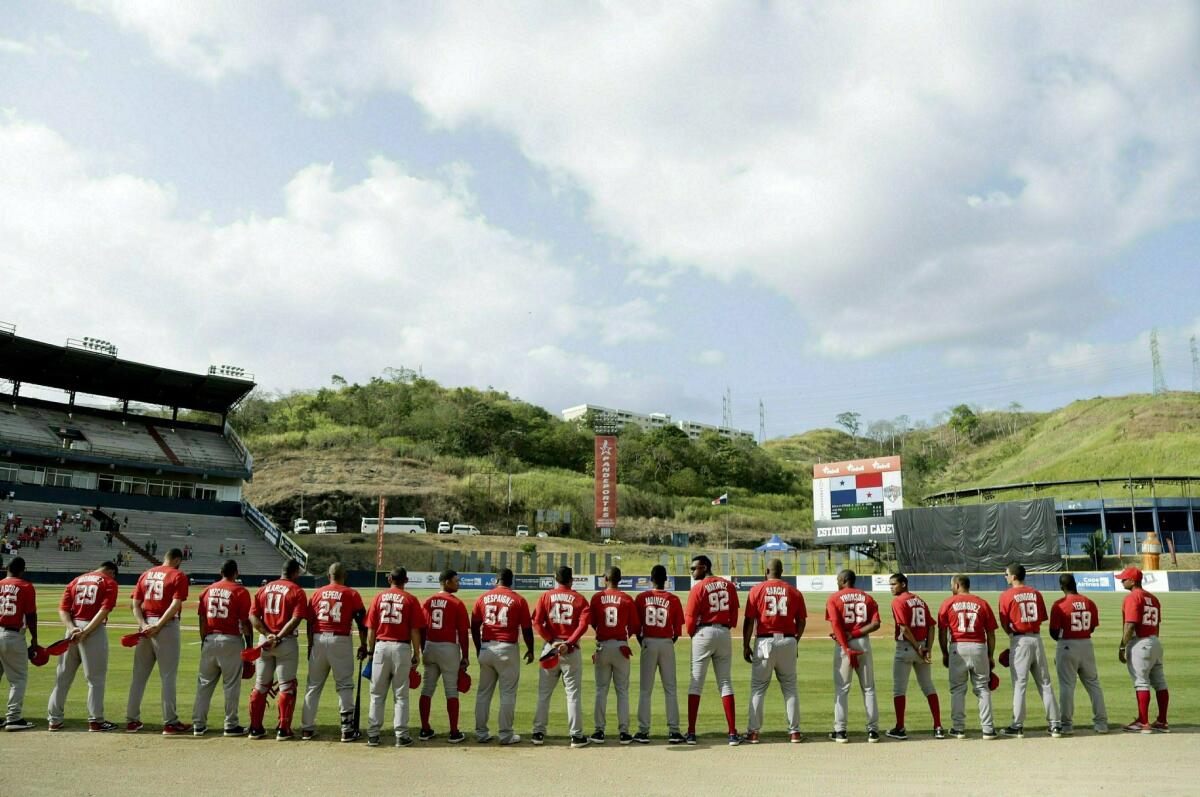 Jugadores del equipo cubano Leñeros de Las Tunas escuchan su himno nacional antes de enfrentar a Los Toros de Herrera de Panamá.