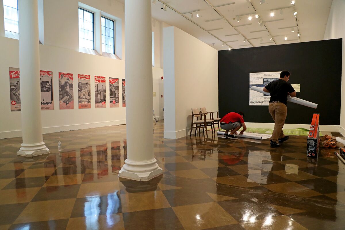 Staffers Jozef Chavez, right, and his brother Raul Chavez, left, clean up an exhibit space