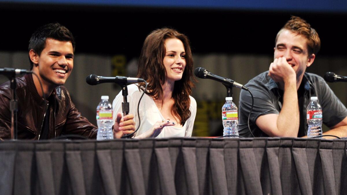 Actors Taylor Lautner, left, Kristen Stewart and Robert Pattinson speak at "The Twilight Saga: Breaking Dawn Part 1" panel.