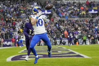 The Rams' Cooper Kupp (10) makes a touchdown catch despite coverage by Ravens safety Marcus Williams.