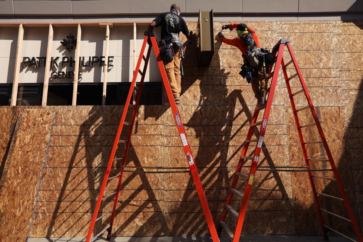Workers board up a store along Rodeo Drive in Beverly Hills.