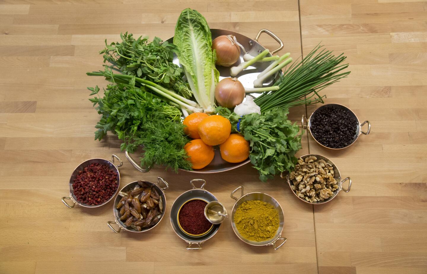 For Nowruz, the Persian New Year, chef Tony Esnault and his family will make three dishes that feature a selection of ingredients: The herbs, onions, oranges and lettuce are for a fried fish and herb rice dish, as well as for the herb-heavy kuku-ye-sabzi. The barberries, from left, go in the kuku; the dates go in the lamb dish; the saffron and Persian spice blend go in all the dishes; the walnuts are for the kuku; and the raisins go in the lamb dish.
