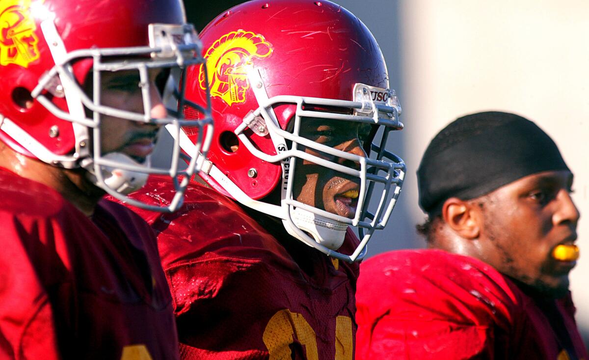 Kenechi Udeze, center, will return to USC as a Trojans assistant strength and conditioning coaching. Udeze is a former USC defensive lineman.