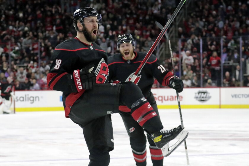 Carolina Hurricanes center Derek Stepan (18) celebrates his goal with defenseman Ian Cole (28) during the second period of the team's NHL hockey game against the Calgary Flames, Friday, Jan. 7, 2022, in Raleigh, N.C. (AP Photo/Chris Seward)